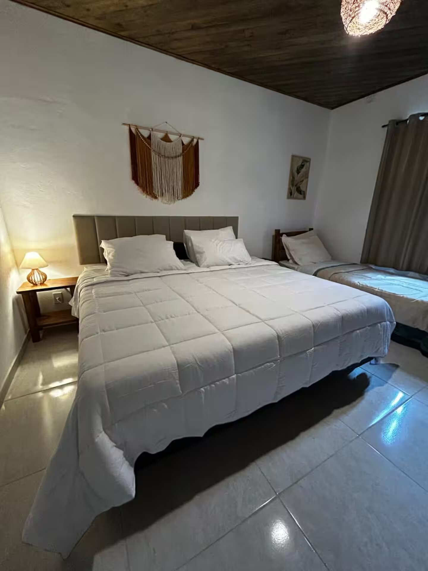 Quarto principal com cama king e macramé na parede